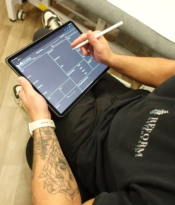 Osteopathic case notes being recorded on a tablet at the clinic